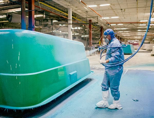 Leisure Pools Tennessee - Worker Spraying Gelcoat On A Fibreglass Pool