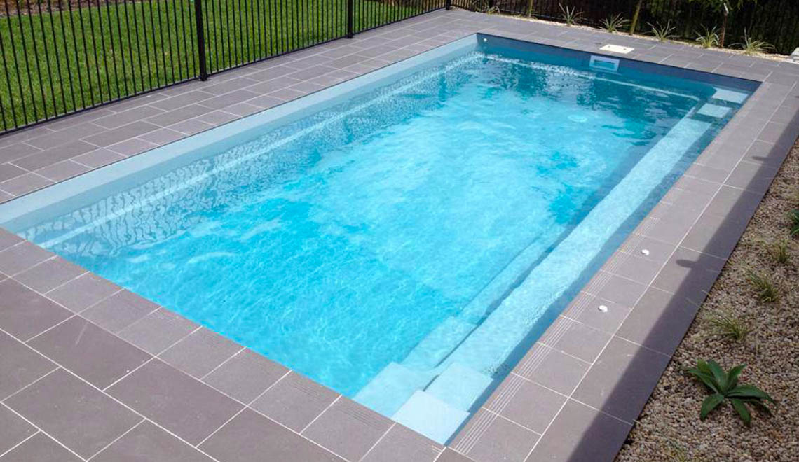 Leisure Pools Reflection composite fiberglass swimming pool with full-length bench seat