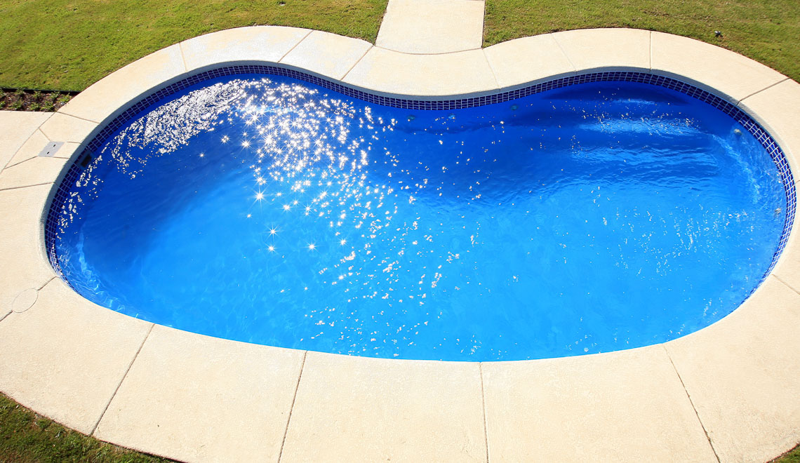 Leisure Pools Tuscany freeform fiberglass swimming pool with perimeter safety ledge