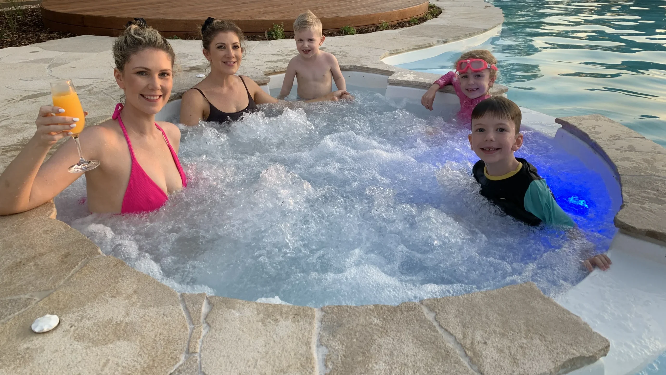 Two female adults and three kids enjoying the built-in spa of the The Allure 12.15m