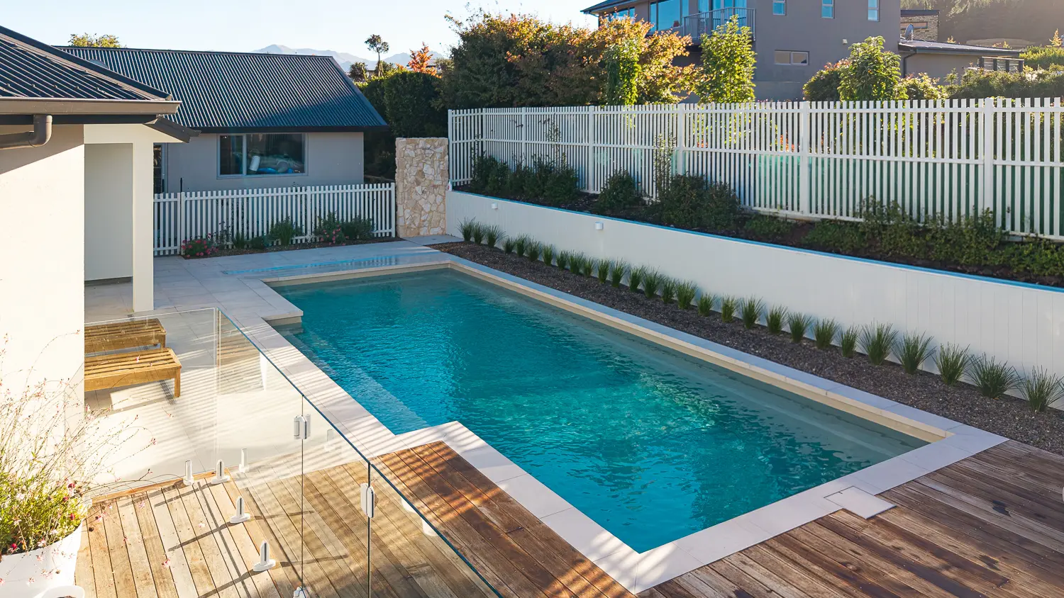 Elegance 10 Diamond Sand Dupont 001 The Elegance 10.00m fibreglass swimming pool is installed in a metropolitan region of Central Otago, New Zealand. The house is surrounded by wooden tiles and natural greenery with mountains in the background. The pool colour is Diamond Sand, which stands out from the resort-like landscape and wooden house.